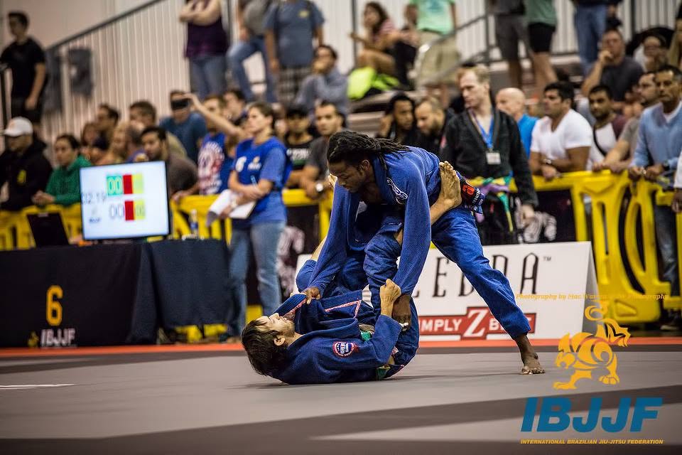 Brien Calloway competing in an IBJJF match, passing guard in a blue gi
