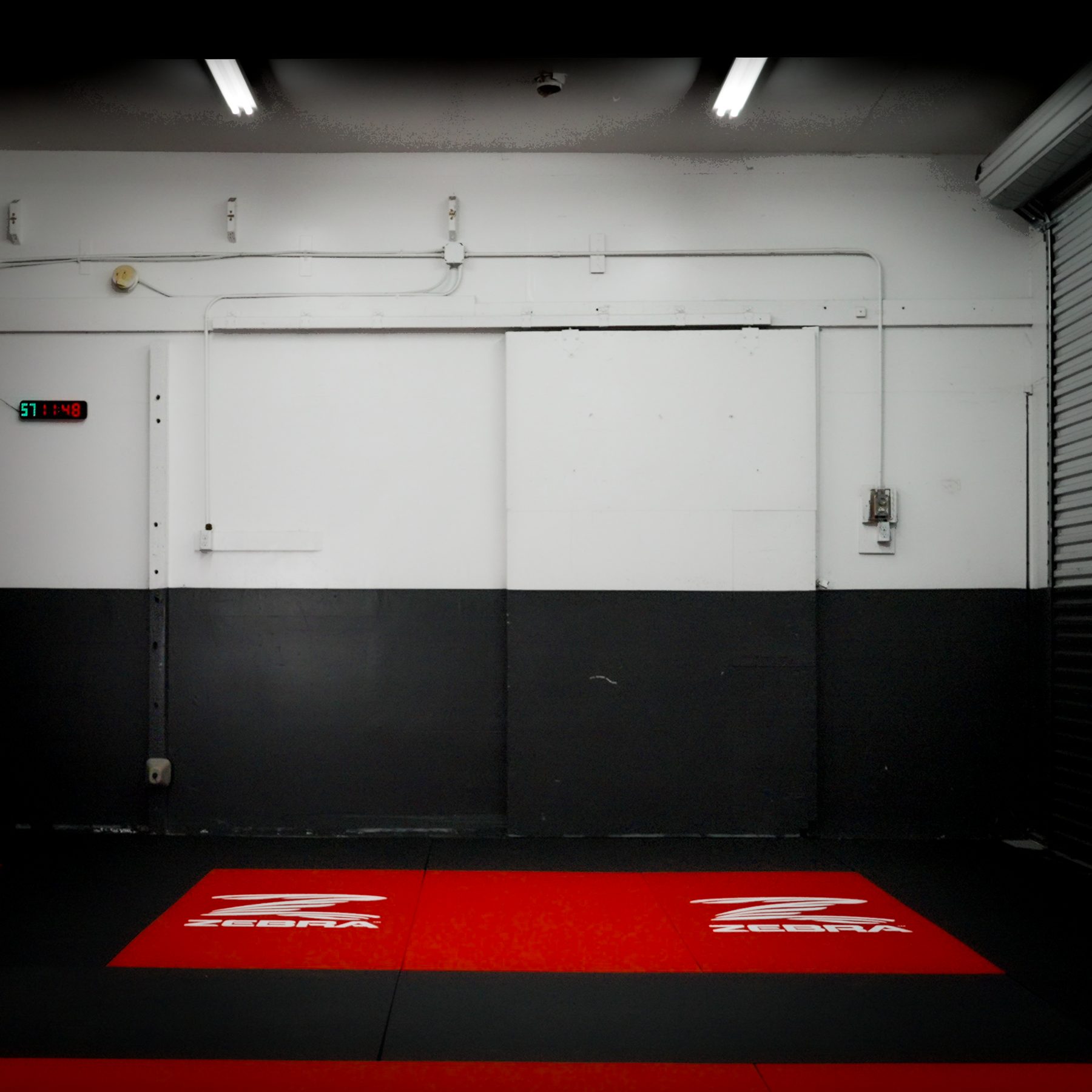 The academy's open training area facing the two-tone wall and roll-up door