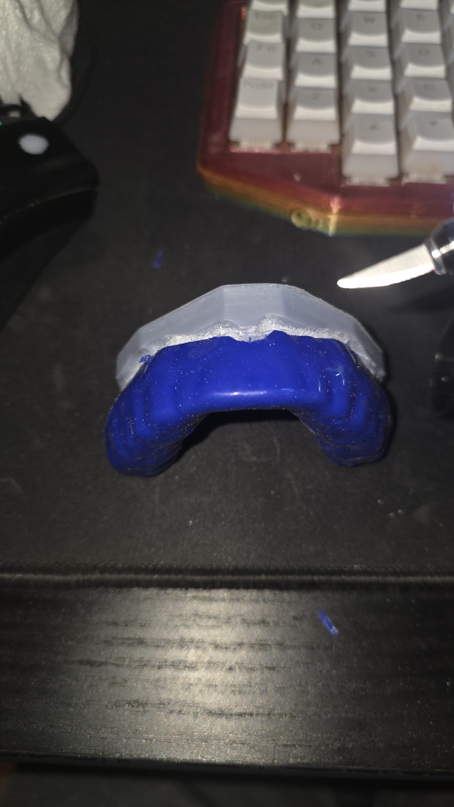 Blue and clear custom mouthguard being hand-trimmed